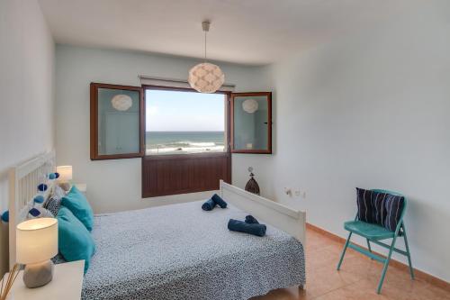 una camera con letto e finestra con vista sull'oceano di Apartamento Abuelo Miguel a Cotillo