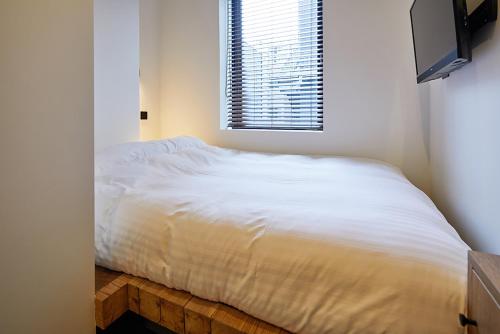 a white bed in a bedroom with a window at mizuka Imaizumi 4 - unmanned hotel - in Fukuoka