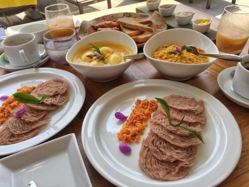 a table with plates of food and bowls of food at Airport Villa in Katunayake