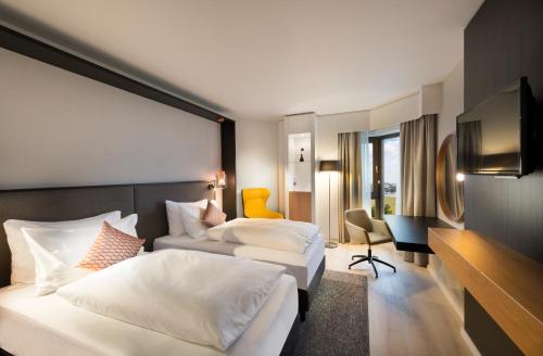 ノイスにあるCrowne Plaza Düsseldorf - Neuss, ein IHG Hotelのベッド2台とテレビが備わるホテルルームです。