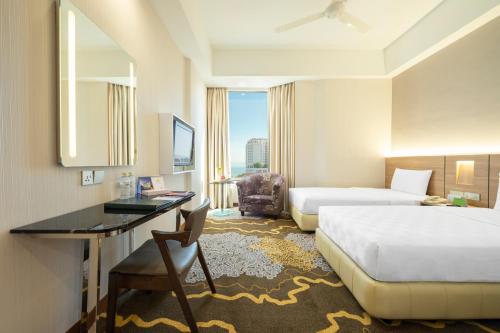 a hotel room with a bed and a desk with a desk at Cititel Penang in George Town
