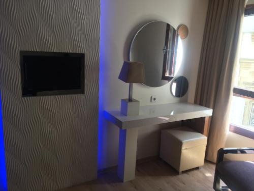 a room with a vanity with a mirror and a tv at Hotel Baylan İzmir in Izmir