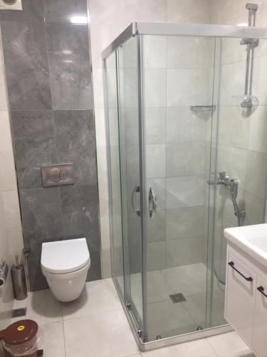 a bathroom with a glass shower with a toilet at Hotel Baylan İzmir in Izmir
