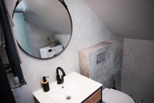 La salle de bains est pourvue d'un lavabo et d'un miroir. dans l'établissement JDK Apartamenty Legionów 40m2 5-osobowy, à Kalisz