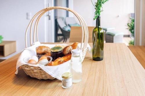 a basket of bread and eggs and a bottle of wine at Baumgartnerhof Sauvigon in Cortaccia