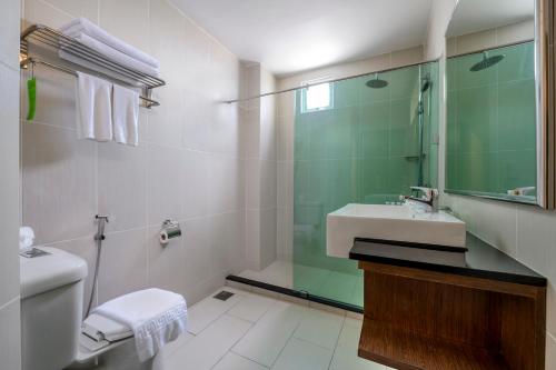 a bathroom with a toilet and a sink and a mirror at Cititel Penang in George Town