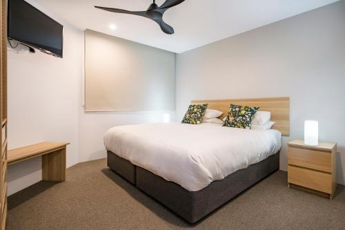 a bedroom with a bed and a flat screen tv at Central Heights - Main Street Views in Margaret River Town