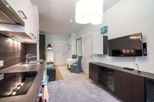 a kitchen with a sink and a tv on the wall at Appartements Mair in Mayrhofen