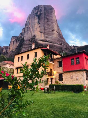 a building with a mountain in the background at Archontiko Mesohori Meteora in Kalabaka