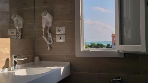łazienka z umywalką i oknem w obiekcie HOTELRISTORANTE IL PUNTO w mieście Marotta