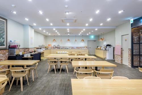 a cafeteria with tables and chairs and a counter at Shin Shin Hotel Cheonjiyeon in Seogwipo