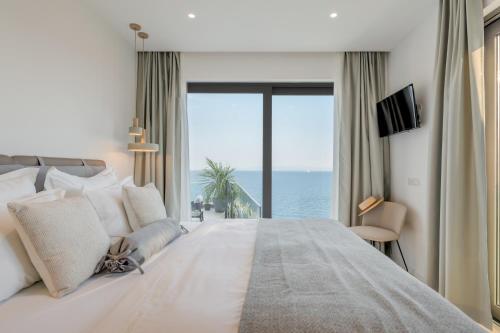 a bedroom with a large bed with a view of the ocean at Villa Juliet in Trogir