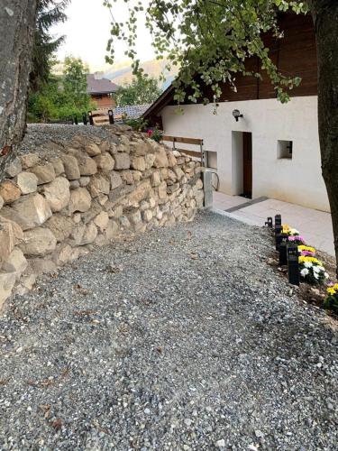 a stone wall in front of a building with a door at Chalet Belmont in Ovronnaz