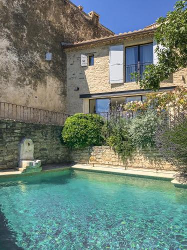 a house with a swimming pool in front of a building at Maison Ventoux in Crillon-le-Brave
