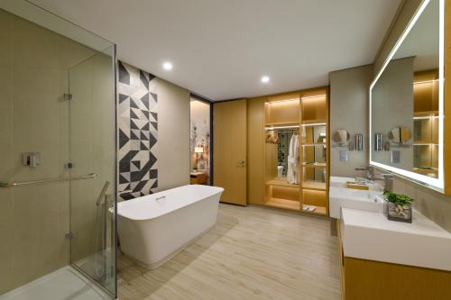 a bathroom with a tub and a sink and a shower at OZO George Town Penang in George Town