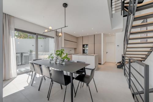 a kitchen and dining room with a black table and chairs at Villa Juliet in Trogir