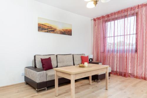 a living room with a couch and a table at Wind Rose Quarter Apartments by Renters in Świnoujście