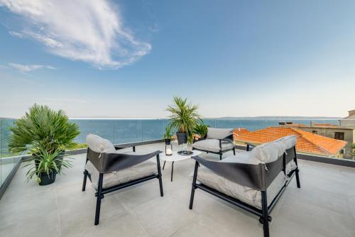a patio with chairs and a table on a balcony at Villa Juliet in Trogir