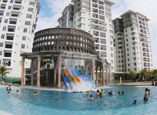 Taman Air Lagoon Resort at A921, unlimited waterpark access, Melaka في ميلاكا: مجموعة من الناس في مسبح مع نافورة مياه