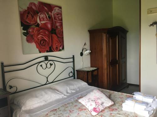 ein Schlafzimmer mit einem Bett und einem Gemälde an der Wand in der Unterkunft Agriturismo Bardari in Curinga