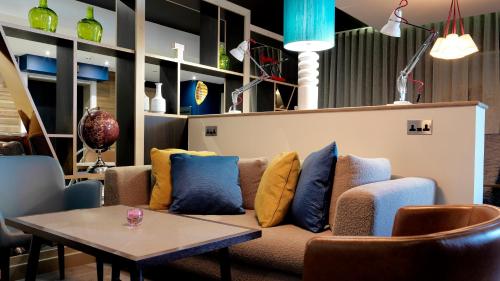 a couch with pillows on it in a room at Crowne Plaza Plymouth by IHG in Plymouth
