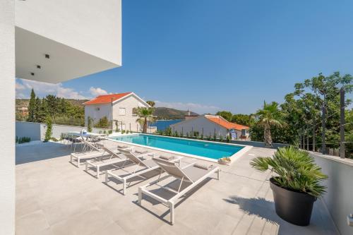 a villa with a swimming pool and lounge chairs at Villa Juliet in Trogir