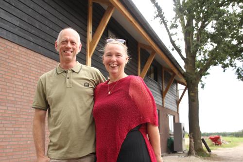 a man and a woman standing in front of a building at B&B In de Wei in Erp