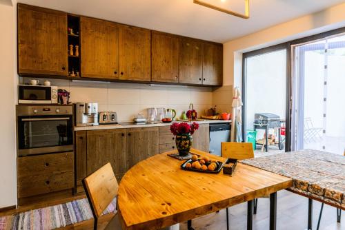 a kitchen with a wooden table with a bowl of fruit on it at Lina Agropanzió in Tomeşti