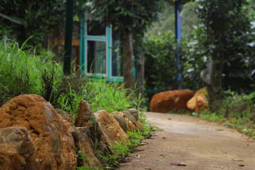 a dirt road with rocks and a blue window at Mu Cang Chai Eco Lodge in Nam San