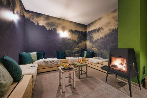a living room with a fireplace and couches at Alpenrose Bayrischzell Hotel in Bayrischzell