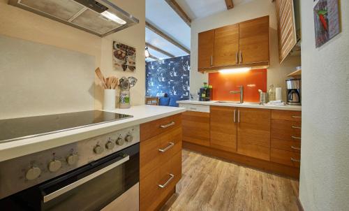kuchnia z drewnianymi szafkami i piekarnikiem w obiekcie Appartement Riverside w Saalbach Hinterglemm