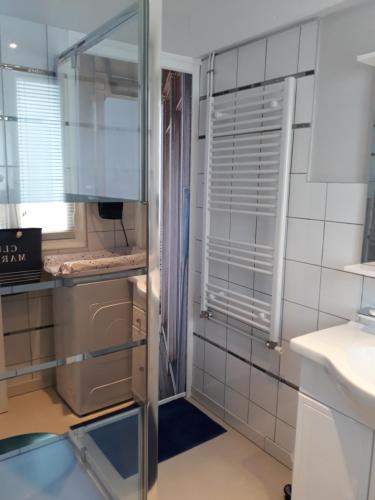 een keuken met witte betegelde muren en een glazen deur bij Cale In in Port-Louis
