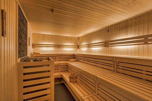 a sauna with wooden benches and lights in it at Alpenrose Bayrischzell Hotel in Bayrischzell