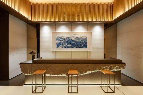 um lobby com um balcão e dois bancos em MGH Mitsui Garden Hotel Taipei Zhongxiao em Taipei