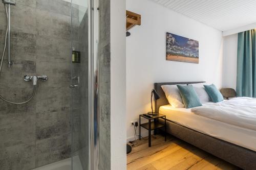 een slaapkamer met een douche en een bed met een glazen deur bij Hotel Clement - Bed & Breakfast in Ingelheim am Rhein