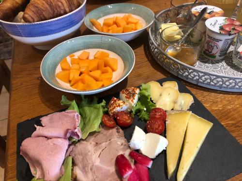 een tafel met een bord vol vlees, kaas en andere gerechten bij Maison Lamothe in Flamarens
