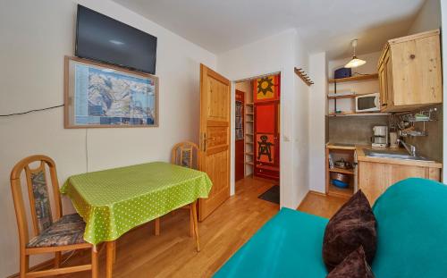 ein Wohnzimmer mit einem Tisch und einer Küche in der Unterkunft Appartement Schattberg in Saalbach-Hinterglemm