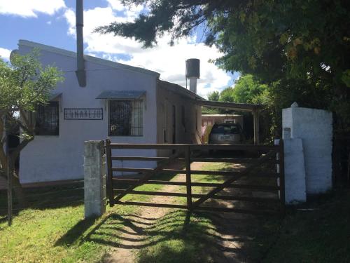 a white house with a gate and a fence at Lunarejo 2 reserva solo con seña in Piriápolis
