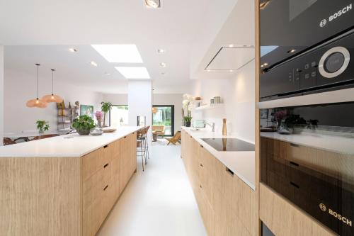 een keuken met witte werkbladen en een grote keuken met een fornuis bij Fabulous 4 bedrooms villa near Zwin with a garden in Knokke-Heist