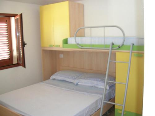 Etagenbett in einem Zimmer mit einem Etagenbett, einem gmaxwell gmaxwell gmaxwell in der Unterkunft Residenza I Gabbiani Valledoria in Valledoria
