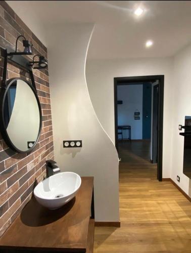 une salle de bain avec un lavabo et un miroir sur un mur dans l'établissement Chesterfield design, à Pierrelatte