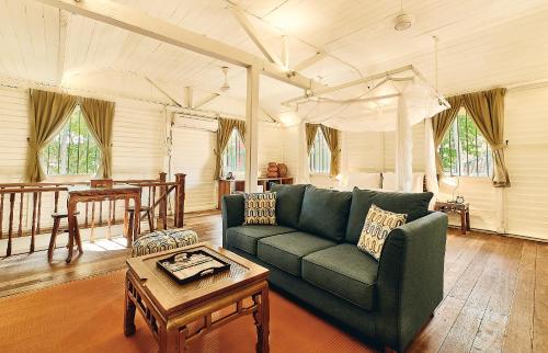 a living room with a green couch and a table at Temple Tree Resort in Pantai Cenang