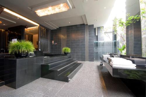 a bathroom with black tiled walls and sinks at Harport Motel in Niaosong
