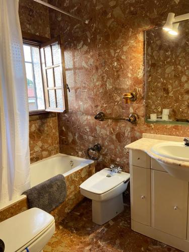a bathroom with a sink and a toilet and a bath tub at Esuri Chalet 300m con 1000m parcela privada a 8min de Puy Du Fou in Argés
