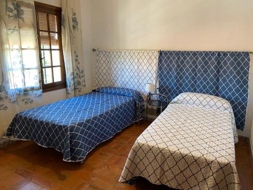 a bedroom with two beds with blue and white sheets at Esuri Chalet 300m con 1000m parcela privada a 8min de Puy Du Fou in Argés