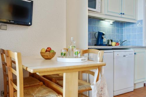 - une cuisine avec une table en bois et un bol de fruits dans l'établissement Résidence Pierre & Vacances Louis Lumière, à Bandol