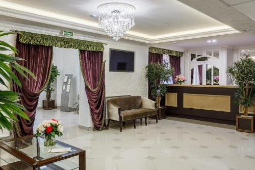 une salle d'attente avec une chaise et une table dans l'établissement Mask Hotel, à Krasnodar
