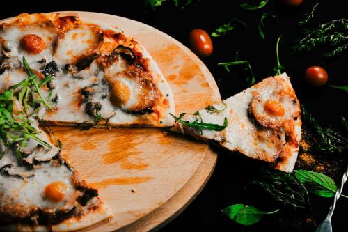 two slices of pizza on a wooden cutting board at Anik Boutique Hotel in Phnom Penh