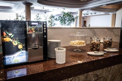 a kitchen counter with a counter top with plates and a microwave at Hotel Gołębiewski Białystok in Białystok
