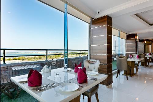comedor con mesa y almohadas rojas en Crown Tower Hotel, en Al Jubail